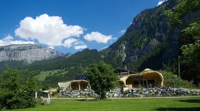 Das Erdhaus vor der Bergkette, Schönwetterwolken über dem Tal