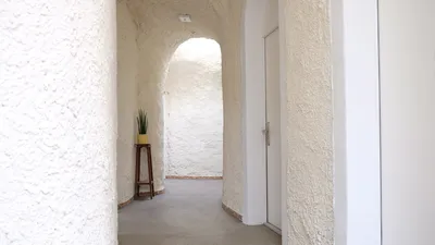 Weiss verputzter Gang im Erdhaus mit rundem Durchgang