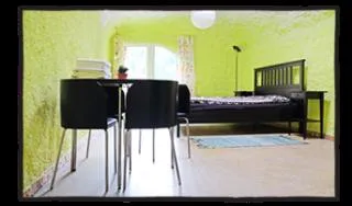 Zimmer 3 im Erdhaus: Bett, dazu Tisch mit vier Stühlen